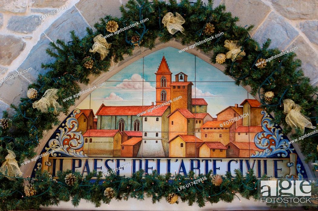 Stock Photo: Antique ceramic wall plaque, Deruta, celebrating tradition of majolica ware production, surrounded by Christmas decorations, illuminated for festive season.