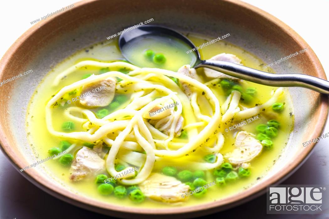 Stock Photo: chicken broth with green peas and noodles.