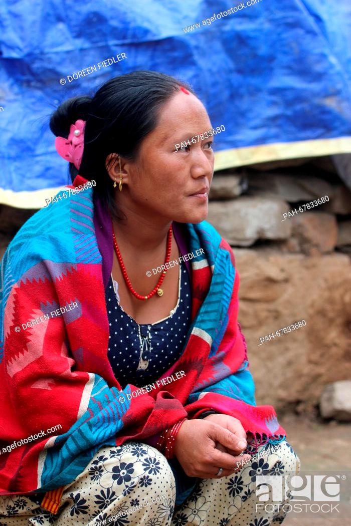 Stock Photo: A Nepalese woman named Makha sits in front of the ruins of her house in Suspa, Nepal, 01 April 2016. Many people in rural regions have no funds for the.