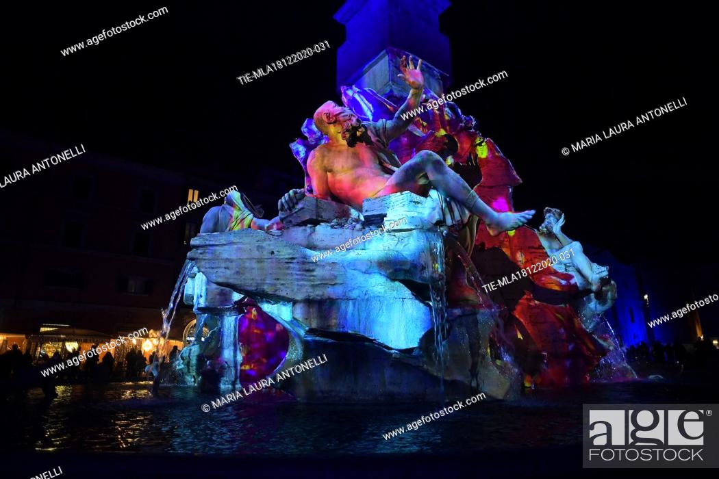 Stock Photo: The Fontana dei quattro fiumi (Fountain of the four rivers) in Piazza Navona illuminated with light shows each night for the duration of the Christmas season.