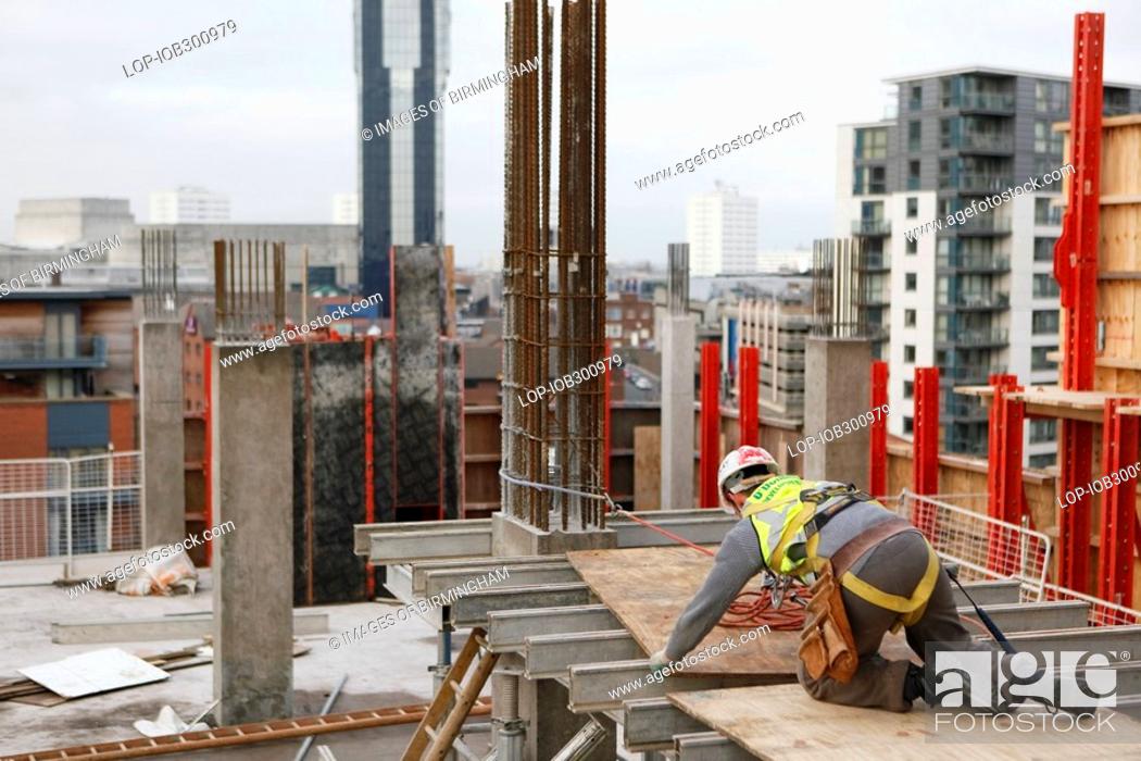 Stock Photo: England, West Midlands, Birmingham, A construction worker on The Cube, an innovative and futuristic development in Birmingham city centre where people will be.