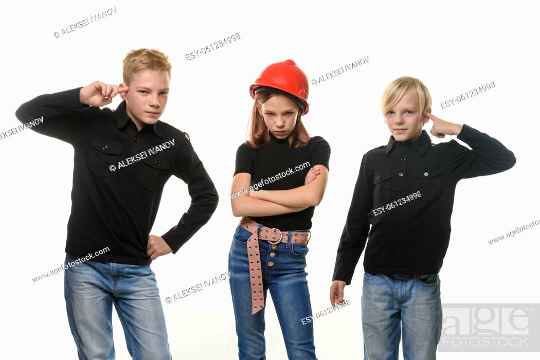 Stock Photo: Two boys tease a girl, the girl is standing in a helmet in a helmet and puffed out her cheeks.