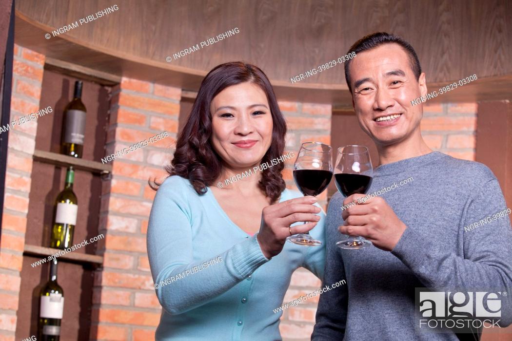 Stock Photo: Mature Couple at a Winetasting, Toasting.