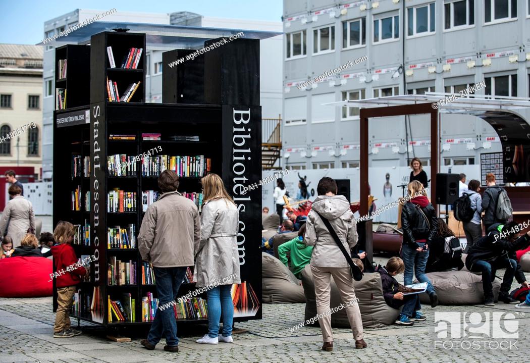 Stock Photo: People stand in front of a giant book shelf at Bebelplatz in Berlin, Germany, 01 May 2014. The public open-air library is part of the reading action.