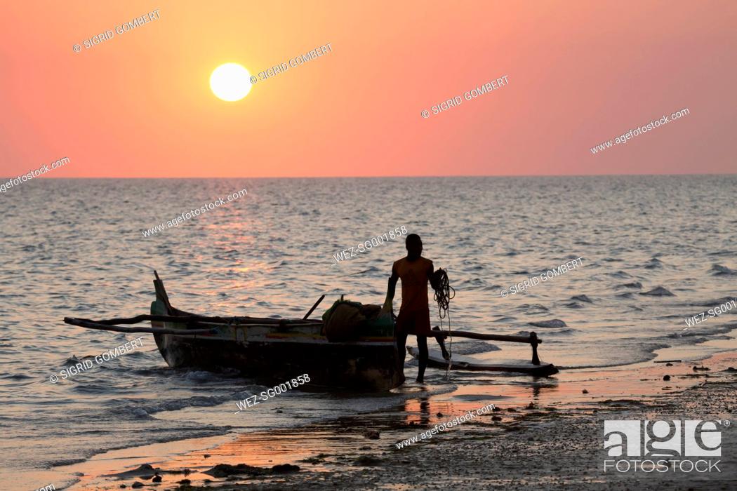 Stock Photo: Africa, Madagascar, Fisherman with pirogue boat at sunset.
