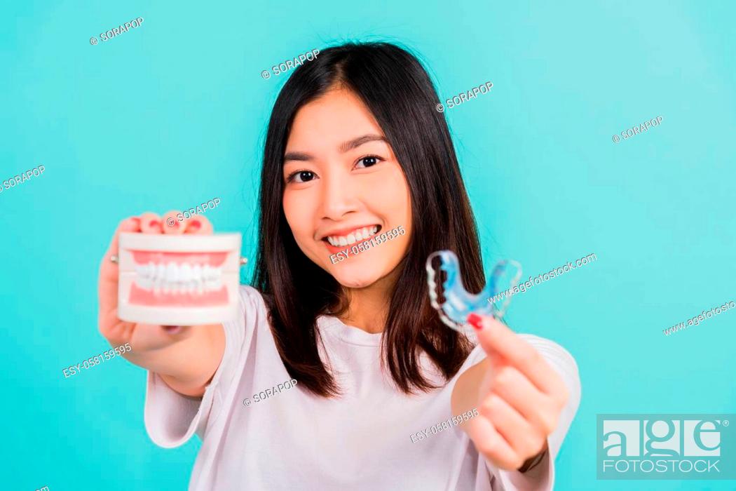Photo de stock: Portrait young Asian beautiful woman smiling holding silicone orthodontic retainers for teeth retaining tools after removable braces.
