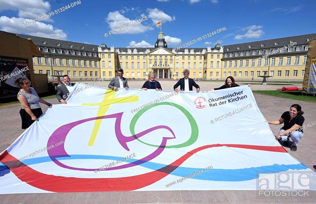 Stock Photo: 25 August 2022, Baden-Wuerttemberg, Karlsruhe: A flag is presented in front of the castle for the 11th Assembly of the World Council of Churches.