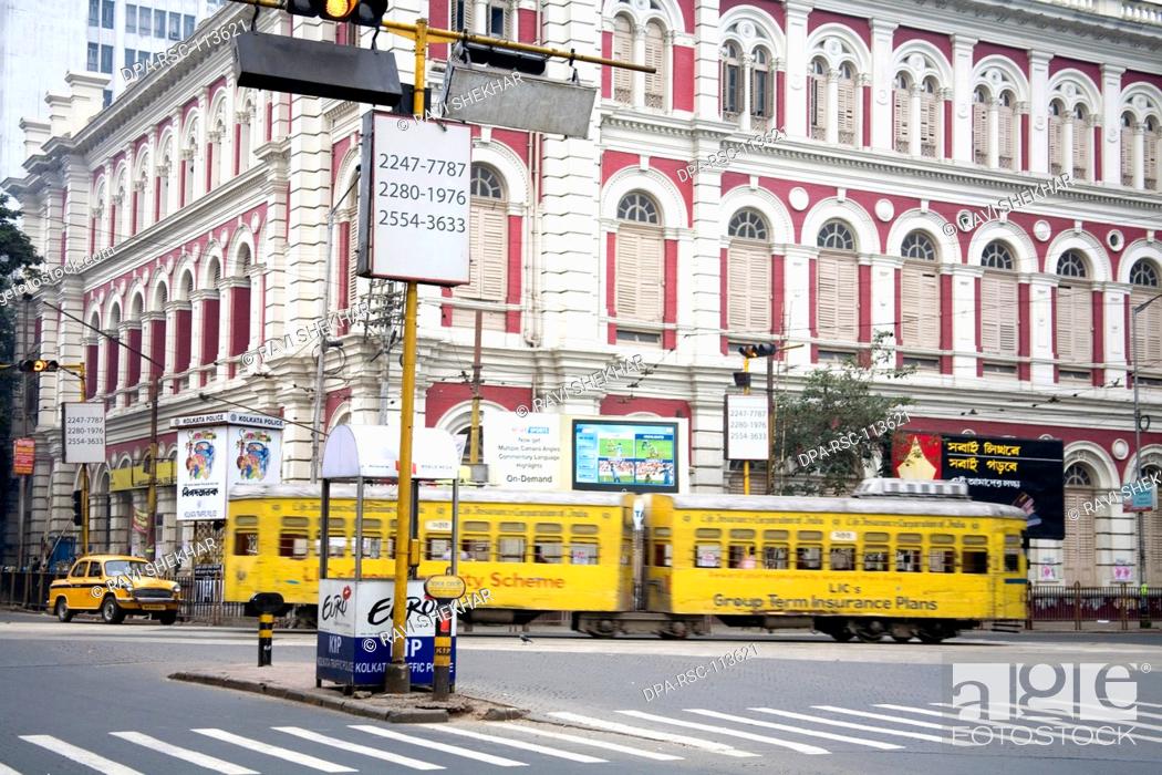 Stock Photo: Tram old way of commuting service passing near building ; Calcutta now Kolkata ; West Bengal ; India.