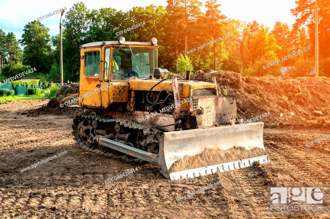 Stock Photo: Old excavator working clearing land at sunset of a Sunny day. The horizontal frame.