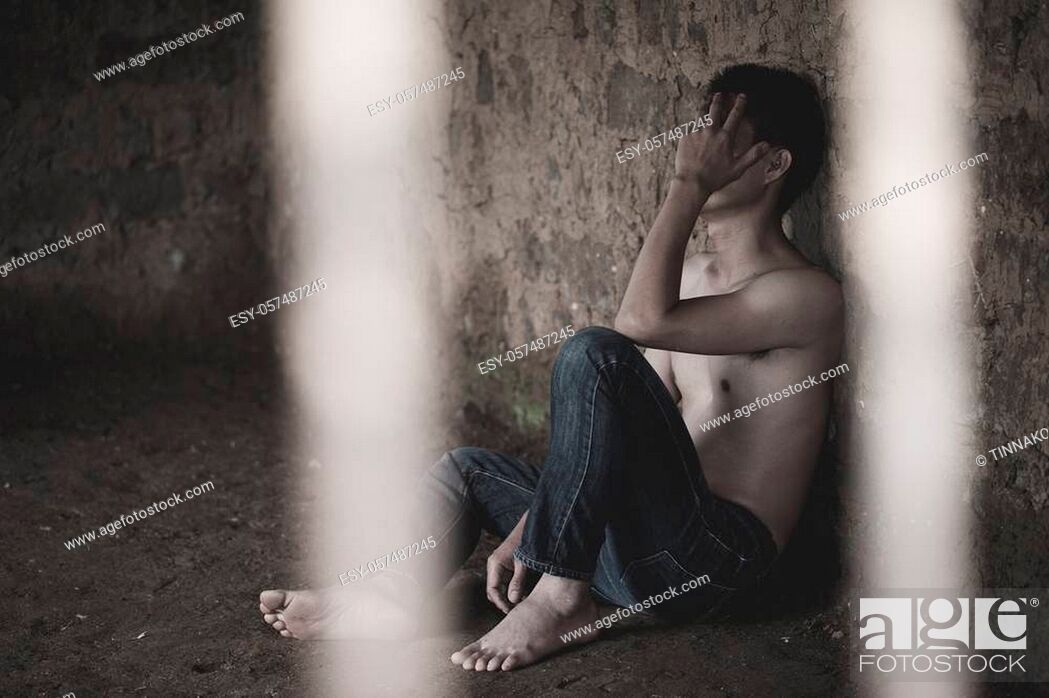Stock Photo: Male prisoners were severely strained in the dark prison, violence, human trafficking, prison and prisoner concept.