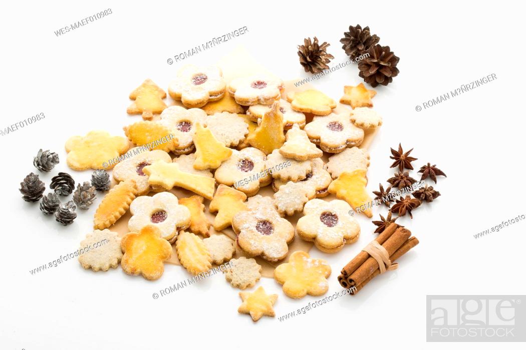 Stock Photo: Different Christmas cookies, spices and pine cones on white ground.