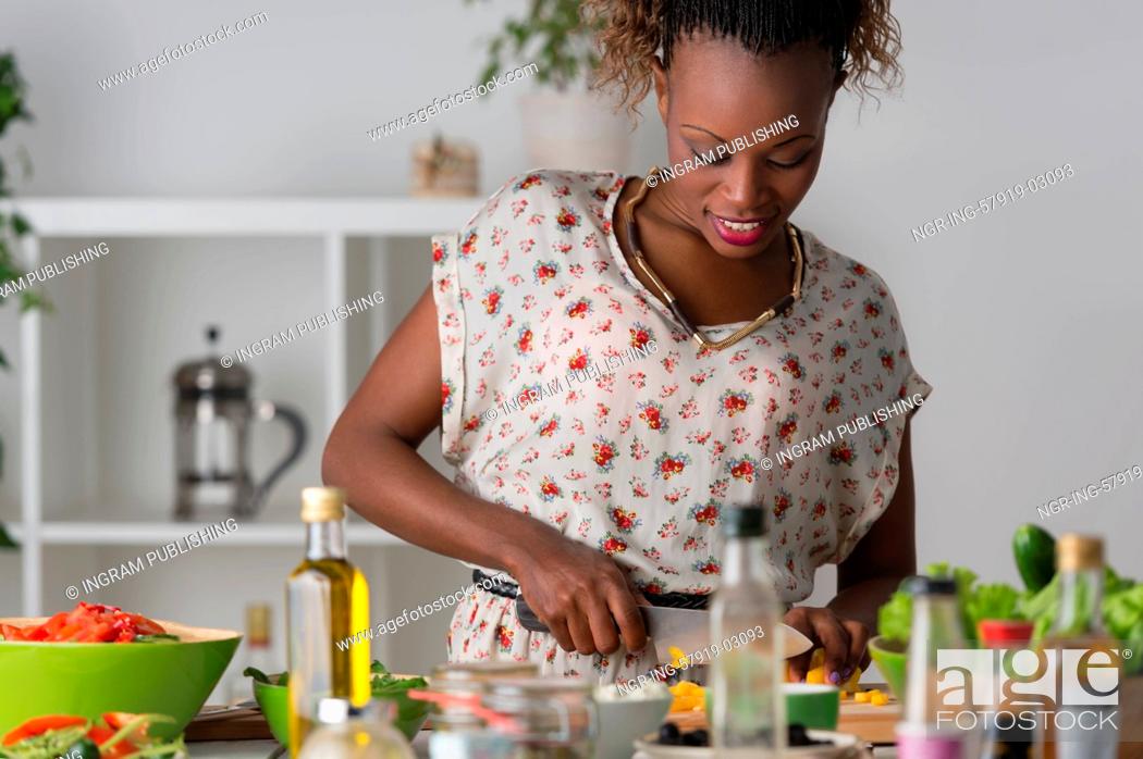Stock Photo: Young African Woman Cooking. Healthy Food - Vegetable Salad. Diet. Dieting Concept. Healthy Lifestyle. Cooking At Home. Prepare Food.
