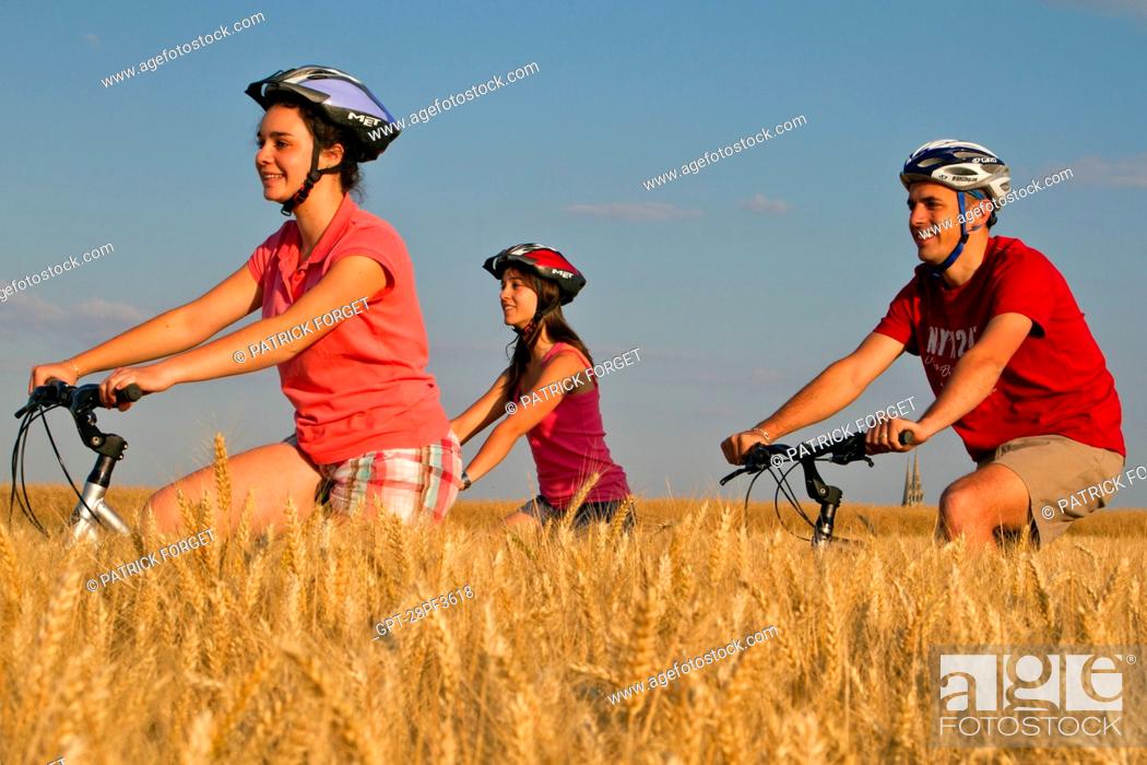 Stock Photo: BICYCLE TOURISTS IN A WHEAT FIELD NEAR CHARTRES, EURE-ET-LOIR 28, FRANCE.