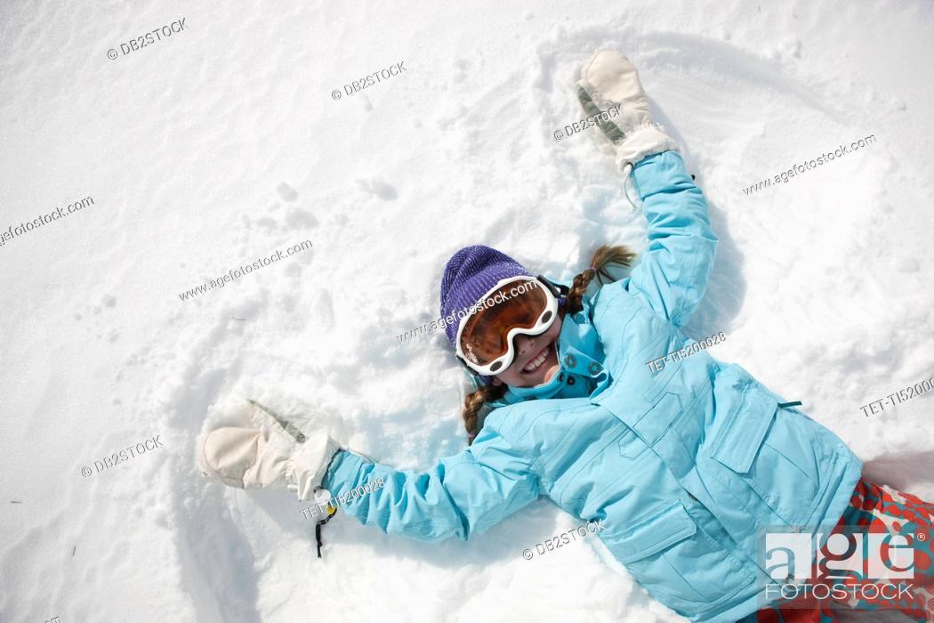 Stock Photo: Girl 10-11 in ski gear doing snow angel.