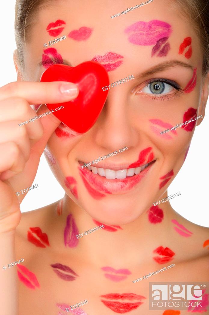 Stock Photo: beautiful woman with kisses on face holding heart eyes.