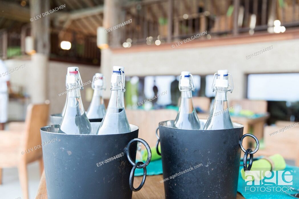 Stock Photo: drinks, thirst, refreshment and summer resort concept - bottles of water in ice bucket at hotel restaurant.