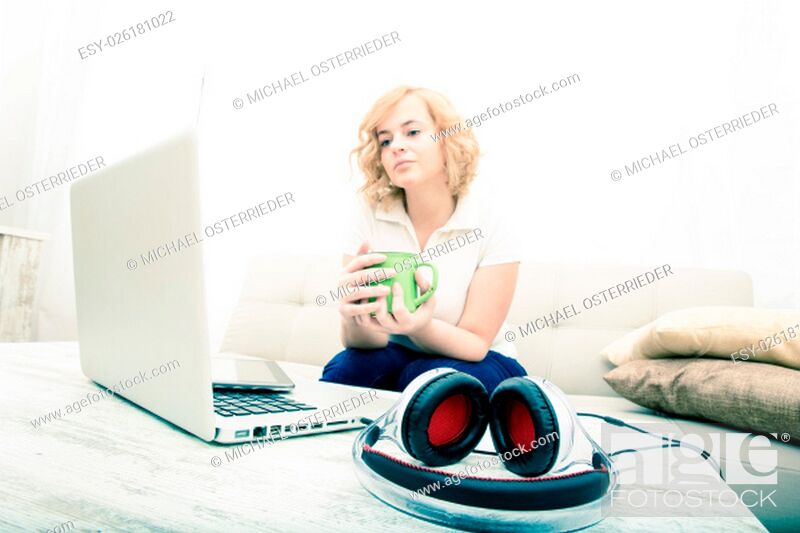Imagen: A young plus size woman sitting on the sofa with a Tablet PC and a Laptop on the Table..