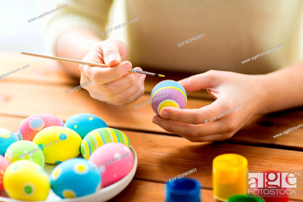 Stock Photo: easter, holidays, tradition and people concept - close up of woman hands coloring easter eggs with colors and brush.
