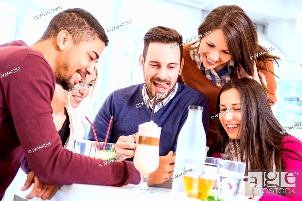 Stock Photo: Shot of a friends having a great time in cafe.Friends smiling and sitting in a cafe, drinking coffee and enjoying together.