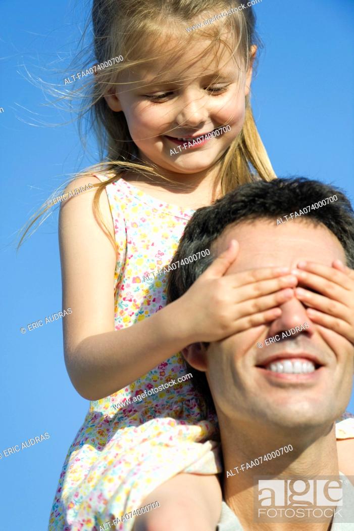 Photo de stock: Girl covering father's eyes with her hands.