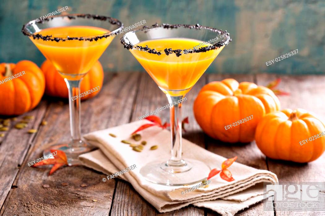 Stock Photo: Pumpkintini pumpkin martini coctail with black salt rim for fall and halloween parties.