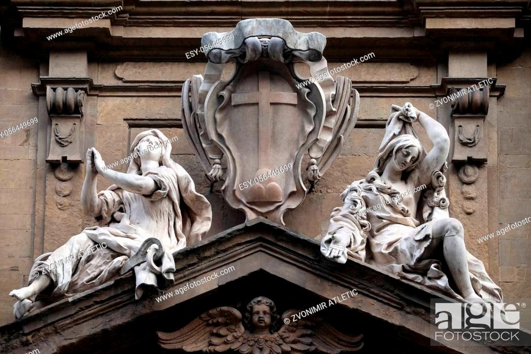 Photo de stock: Statues of Hope and Poverty seated either side of the arms of the Theatine order over the central door on the facade of Santi Michele e Gaetano church in.