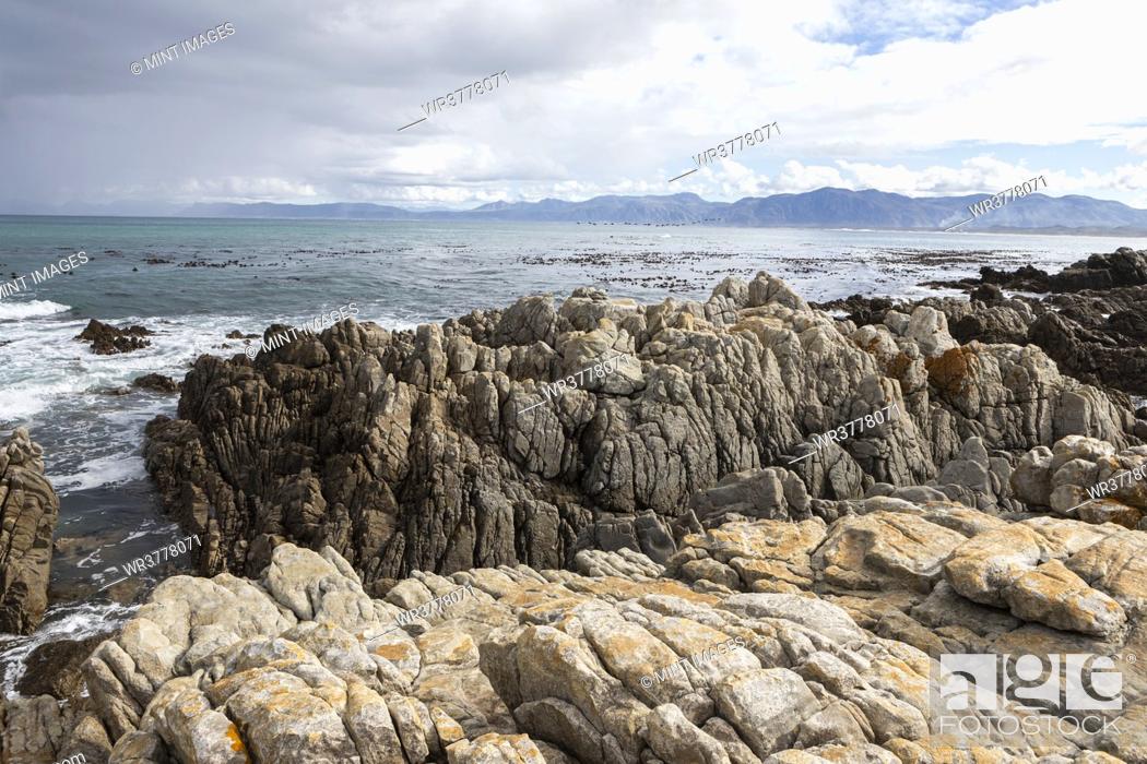 Stock Photo: Rocky jagged coastline, eroded sandstone rock, view out to the ocean.