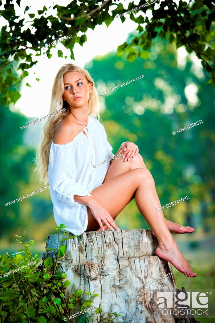 Portrait of young beautiful blonde woman wearing white dress, sitting on  stump in summer green park, Stock Photo, Picture And Low Budget Royalty  Free Image. Pic. ESY-028245992 | agefotostock