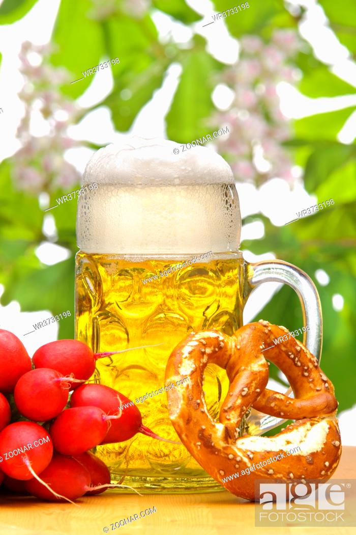 Imagen: big glass filled with Bavarian lager beer and snack for beer garden.