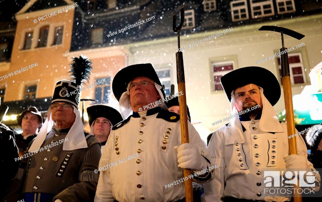 Stock Photo: 10 December 2022, Saxony, Oberwiesenthal: Actors of miners' clubs stand on the market square. A traditional mining parade took place there.