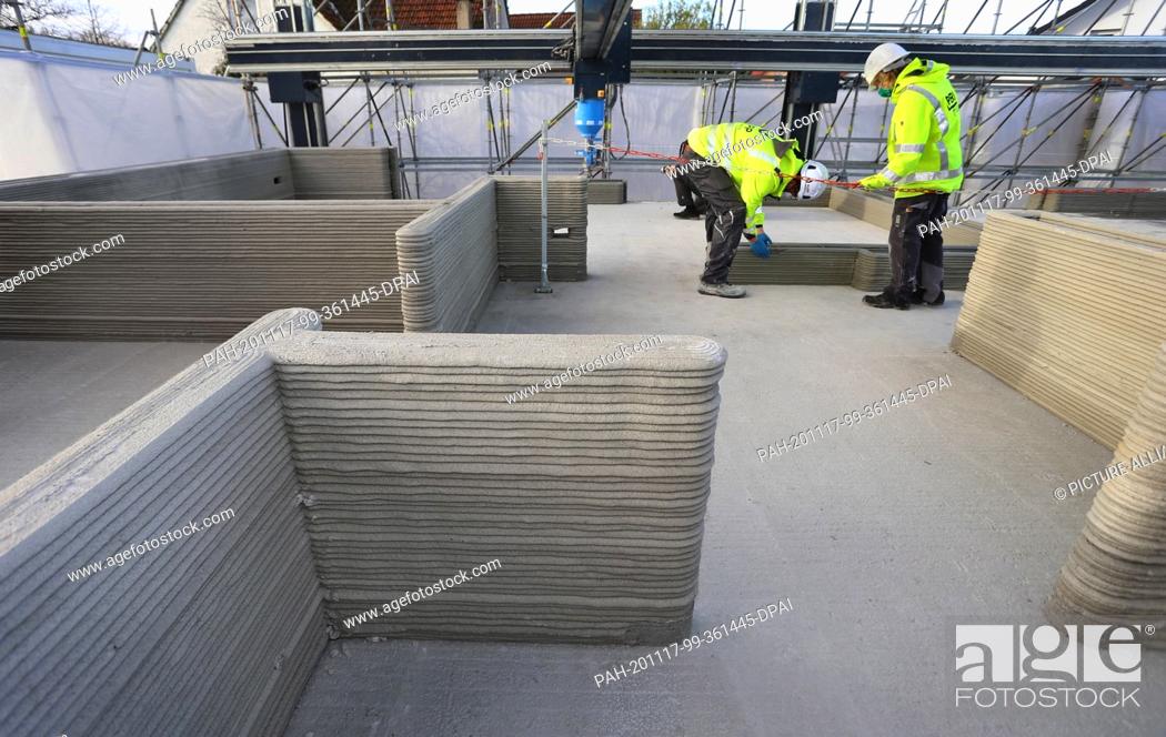 Stock Photo: 17 November 2020, Bavaria, Weißenhorn: Walls are built in layers on the first floor of a building shell using a 3D concrete printer.