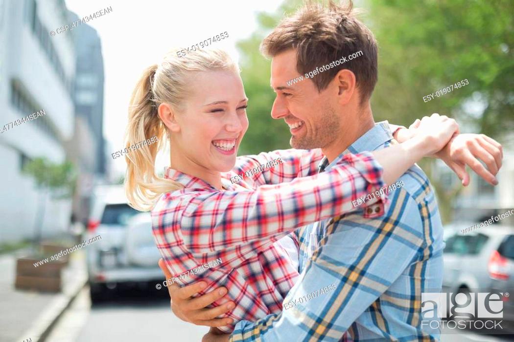 Stock Photo: Couple in check shirts and denim hugging each other.