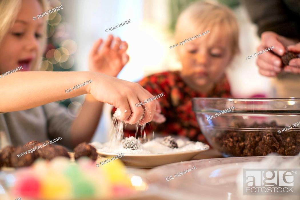 Stock Photo: Mother and daughters baking for Christmas.