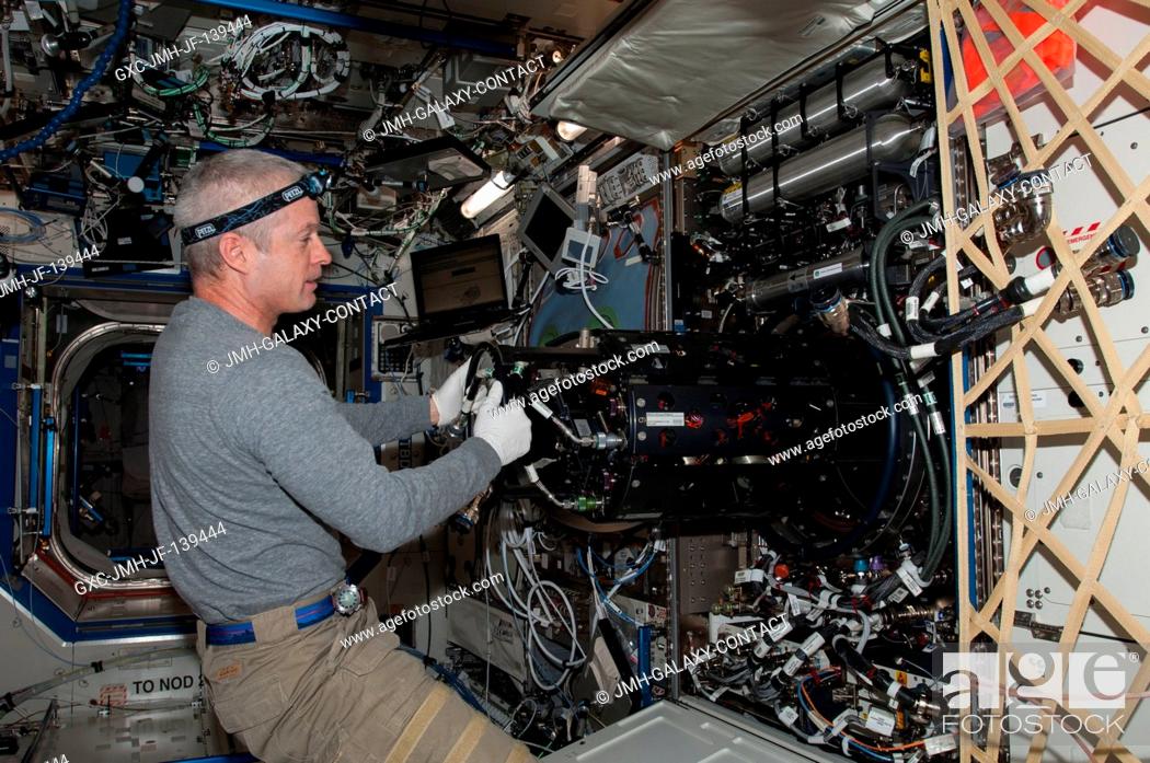 Stock Photo: NASA astronaut Steve Swanson, Expedition 40 commander, works with the Multi-user Drop Combustion Apparatus (MDCA) inside the Combustion Integrated Rack (CIR) in.