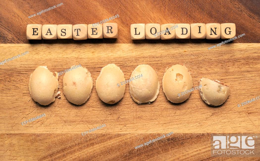Stock Photo: Sweet Easter eggs as loading bar on a wooden board, wooden cubes with the inscription Easter loading.