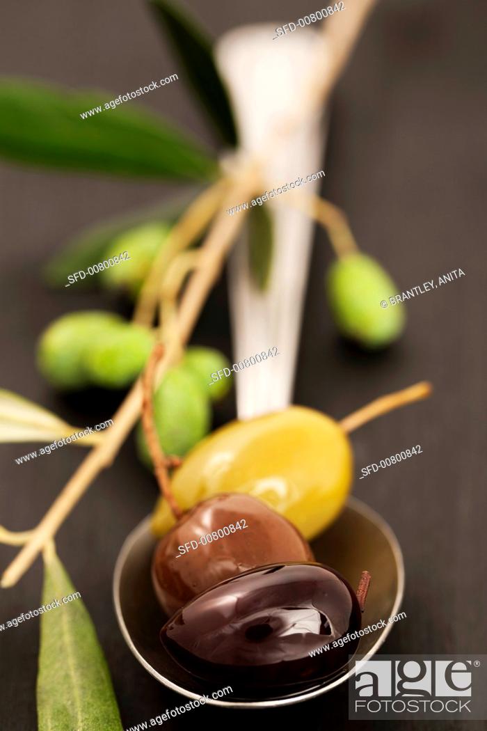 Stock Photo: Three different olives and an olive twig.
