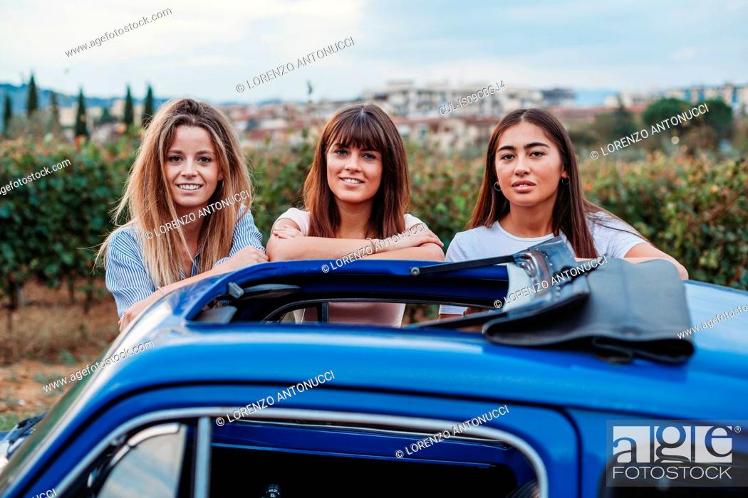 Stock Photo: Friends posing beside car in countryside, Florence, Toscana, Italy.