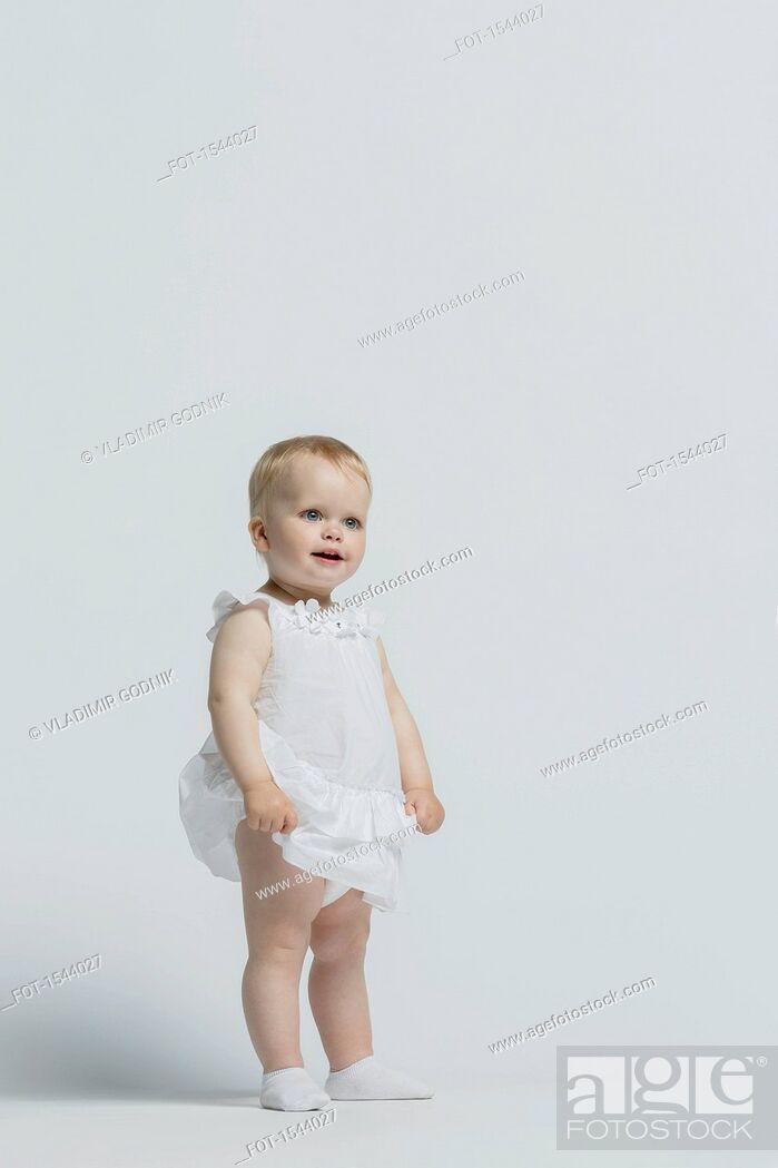 Imagen: Girl wearing dress standing against white background.