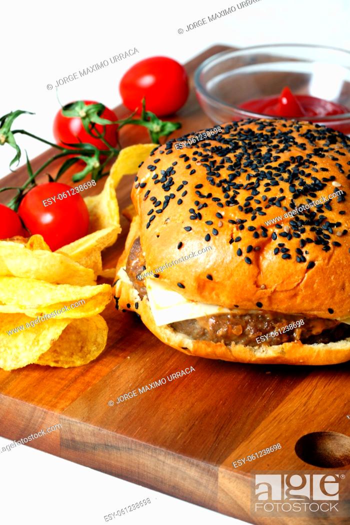 Stock Photo: Cheeseburger with fries and cherry tomato on a wooden board.