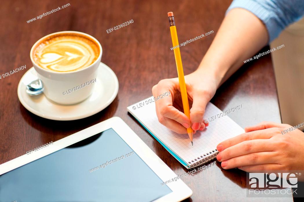 Stock Photo: business, education, people, technology and lifestyle concept - close up of woman hands writing to notebook by pencil and tablet pc computer with coffee.