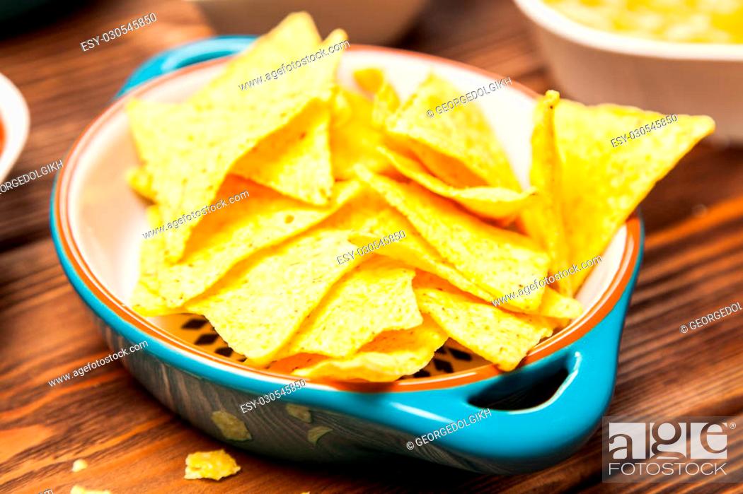 Stock Photo: Plate of nachos with salsa, cheese and guacamole dips.