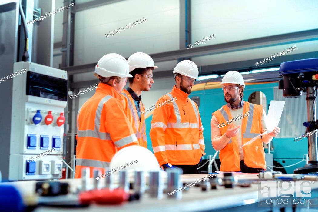 Stock Photo: Group of apprentices with instructor at railway engineering facility.