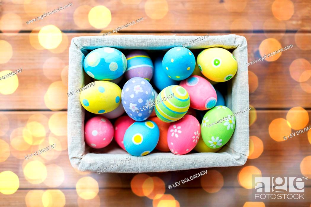 Stock Photo: easter, holidays, tradition and object concept - close up of colored easter eggs in basket.