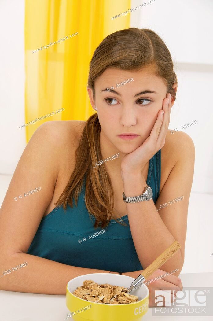 Stock Photo: Teenage girl refusing to eat her cereals suffering from anorexia.