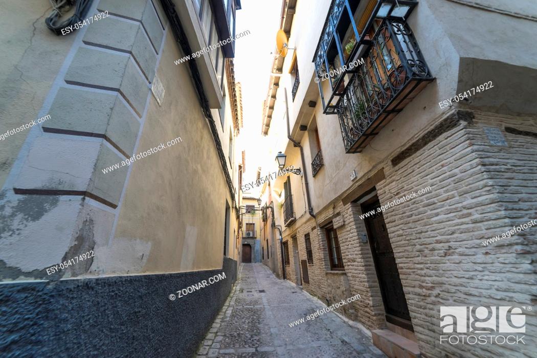 Stock Photo: Medieval cobbled and stepped street with flowery balconies and public lighting lamps in the city of Toledo. Spain.