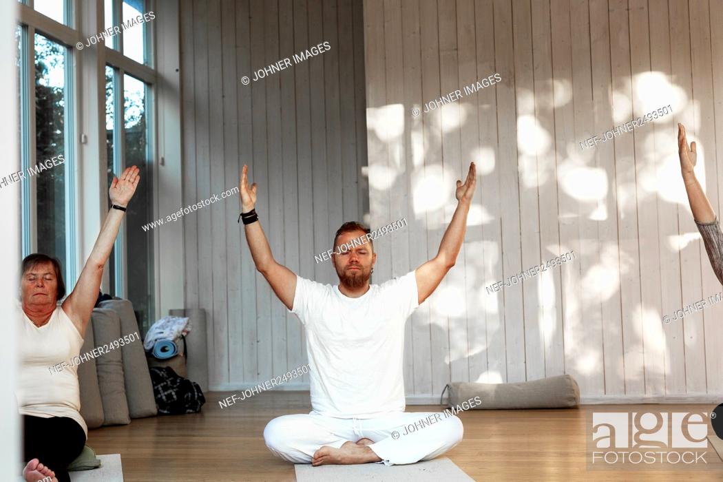 Stock Photo: People practicing yoga in class.
