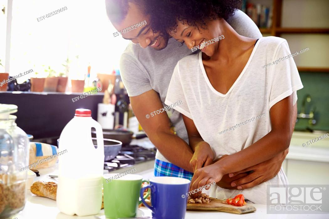 Stock Photo: Young Couple Preparing Breakfast In Kitchen Together.