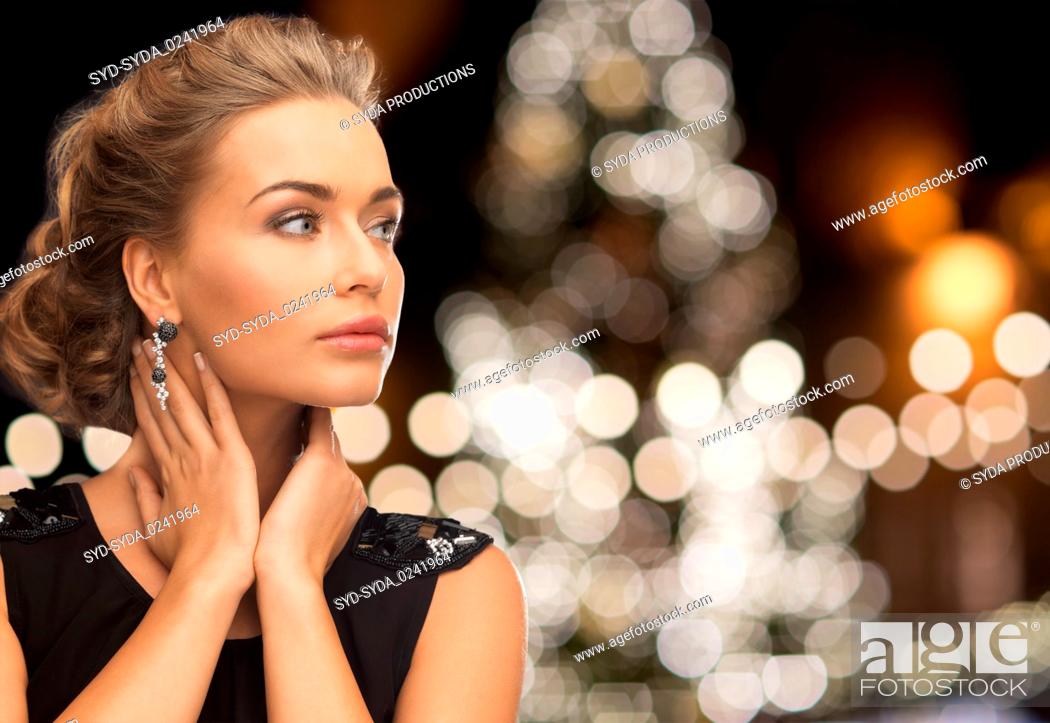 Stock Photo: woman wearing jewelry over christmas lights.
