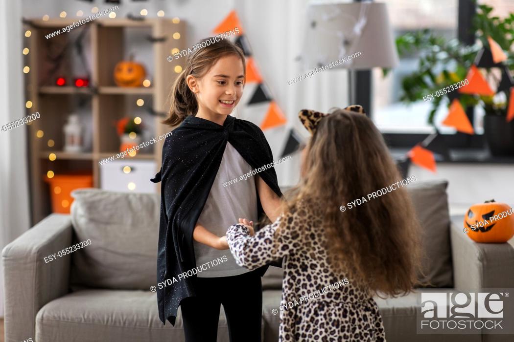 Stock Photo: girls in halloween costumes dancing at home.