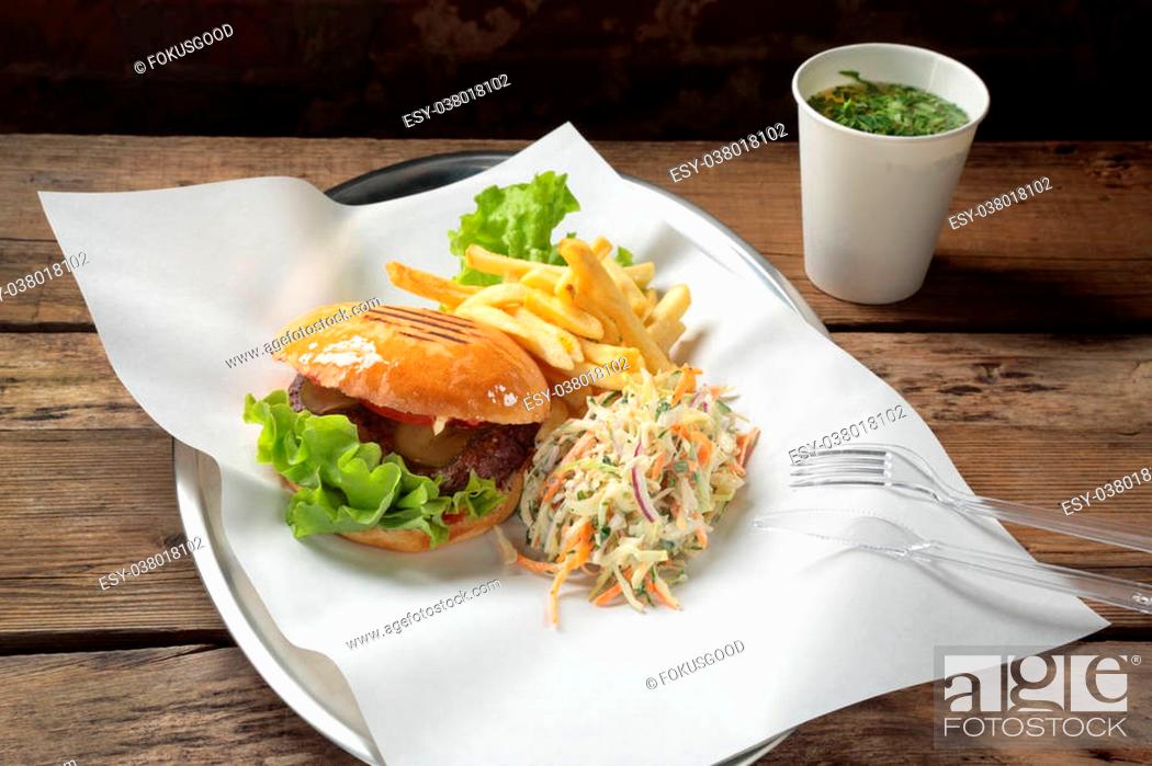 Stock Photo: Lunch with a burger, fries, salad and sauce in a glass.